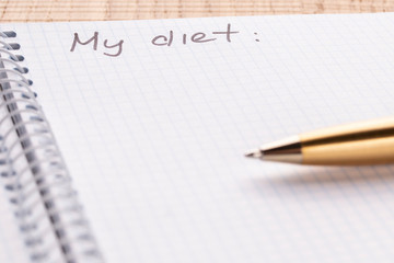 Top view workplace notebook and pen on wood table background, retro effect. Inscription - My diet. The concept of healthy eating and sports lifestyle