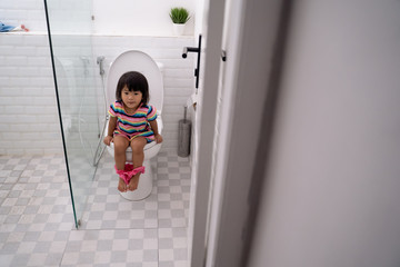 child sitting and learning how to use the toilet