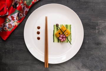 Fototapeta na wymiar Tamagoyaki on a plate, top view stone background, copy space