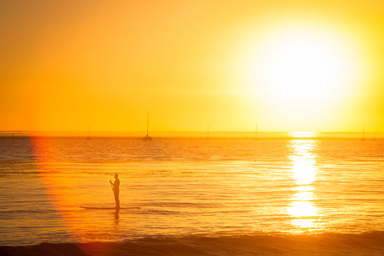Paddleboarder Cruises Along Montecito Beach During Sunset