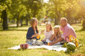 Foto op Canvas Happy family with smiles picnic in the park on a sunny day © Anton