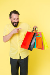 Shopping happiness. Man emotional enjoying shopping. Bearded mature man with shopping bag on yellow background. Sale and discount. Online shopping. Profitable purchase. Shop assistant or sales expert