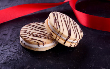 Delicious desserts on a black background. Cookies and marshmallows on the background. Fragrant dessert.