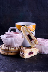 Delicious desserts on a black background. Cookies and marshmallows on the background. Fragrant dessert.