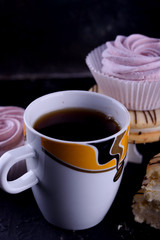 Delicious desserts on a black background. Cookies and marshmallows on the background. Fragrant dessert.