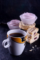 Delicious desserts on a black background. Cookies and marshmallows on the background. Fragrant dessert.