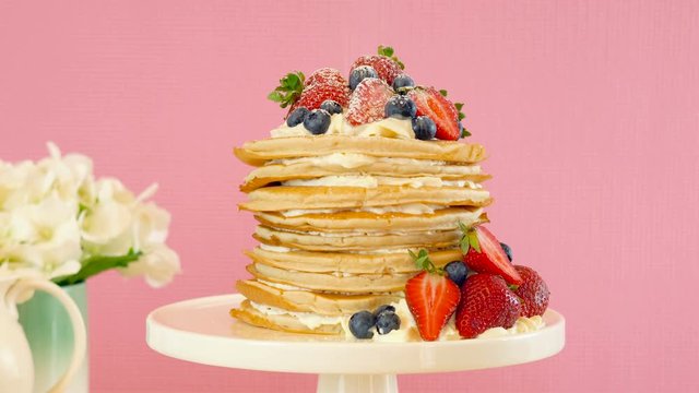 Shrove Pancake Tuesday, last day before Lent, stack of pancakes cake prepared with layers of whipped cream and fresh berries.