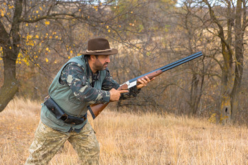 Hunter with a hat and a gun in search of prey in the steppe	