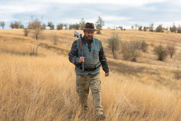 Hunter with a hat and a gun in search of prey in the steppe	