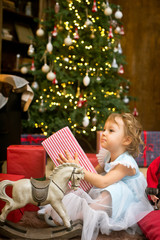 Obraz na płótnie Canvas little girl under the christmas tree with christmas gifts