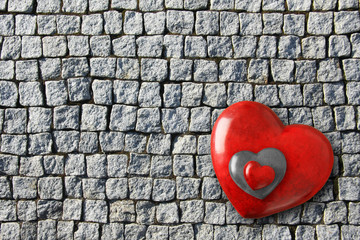 Three Red Valentines hearts stacked on vintage old brick cobblestones. 