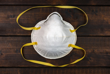 dust mask - respirator on dark brown wooden background