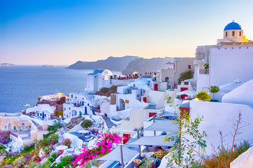 Travel Destinations. People Preparing for Sunset at Caldera Volcanic Slope of Oia Village in...