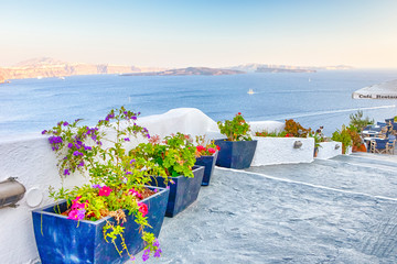Fototapeta na wymiar Travel Destinations.Picturesque Cityscape of Oia Village in Santorini with Volcanic Caldera and sailing Boats on Background.