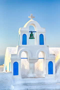 Famous European Destinations. Classic White Roofed Chirch with Blue Inserts and Bell on Oia Village in Santorini Island in Greece