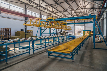 Fototapeta na wymiar Modern thermal insulation sandwich panel production line. Machine tools, roller conveyor and overhead crane in workshop