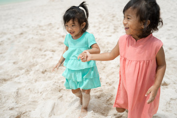 two little girl smile when playing together at the beach