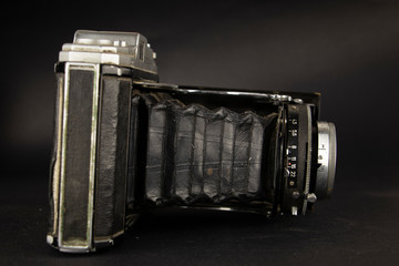 Bellows analogue camera on the black background and it like vintage or retro concept.