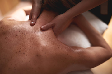 Top view of young lady having massage of neck