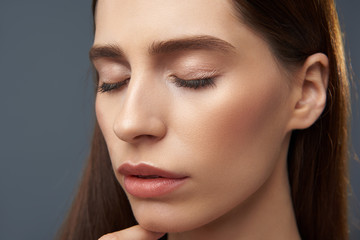 Naklejka premium Beautiful peaceful girl with perfect skin isolated on blue-gray background
