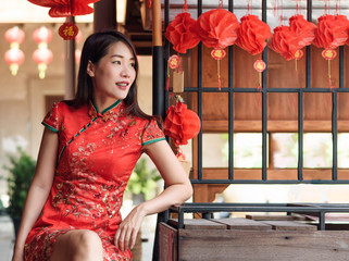 asian woman wearing red traditional dress in chinese new year festival background with lanterns having letter meaning goodluck and success