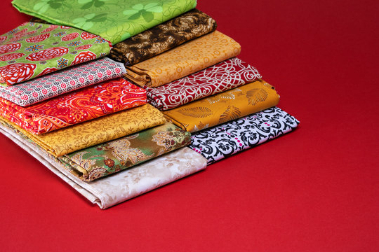 Stack of folded cotton fabric in a variety of colors and patterns for quiling and sewing projects