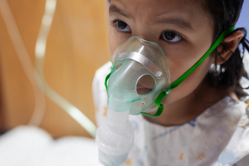 Asian child girl has asthma or pneumonia disease and need nebulization by get inhaler mask on her...