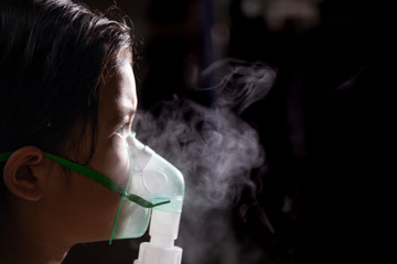 Asian child girl has asthma or pneumonia disease and need nebulization by get inhaler mask on her face
