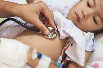 Doctor examining asian child girl and listen her lung and heart sound with stethoscope in the hospital