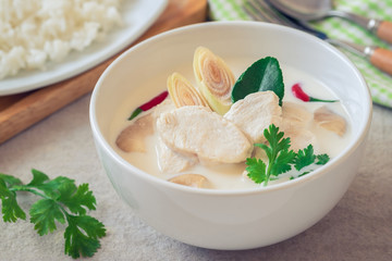 Chicken with coconut milk soup in bowl and rice on plate , Thai food (Tom Kha Kai).