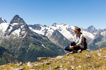 Fototapeta premium tourist girl sitting on a background of mountains