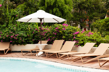 sun beds under umbrellas by the pool