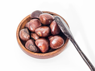 Closeup of brown Chestnuts in the wooden cup with wooden spoon