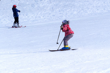 Fototapeta na wymiar Children have fun and relax in the mountains in winter skiing.