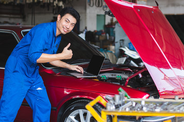Professional mechanic working in auto repair service,with laptop,very good engine
