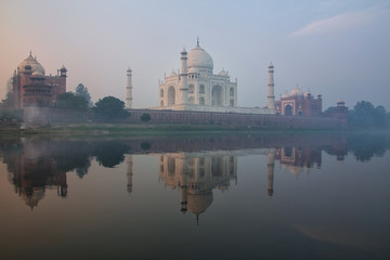 Fototapeta na wymiar View of Taj Mahal with early morning fog reflected in Yamuna River, Agra, Uttar Pradesh, India