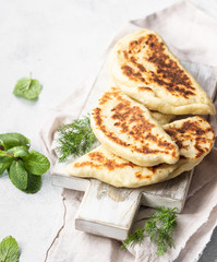 Frying pan baked flat bread with fresh herbs and yogurt dressing. Khychiny or qutab - traditional caucasian or Azerbaijani flatbread.