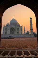 Fototapeta premium Taj Mahal at sunrise framed with the arch of the mosque, Agra, Uttar Pradesh, India