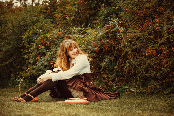 Beautiful girl in a vintage dress in a Summertime park. Roses