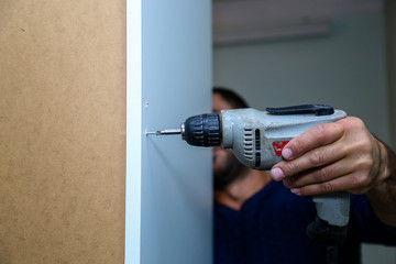 Worker use drill to repair furniture