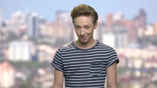 Cunning teen boy on blurred background. Emotional portrait of caucasian teenage boy. Teen guy having a plan.