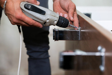 Worker use drill to repair furniture