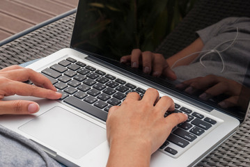 The hands of women who are typing on a laptop