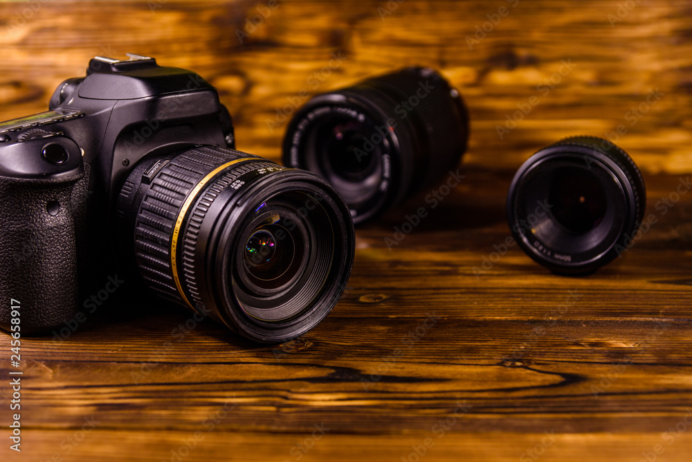 Wall mural modern dslr camera and lenses on wooden table