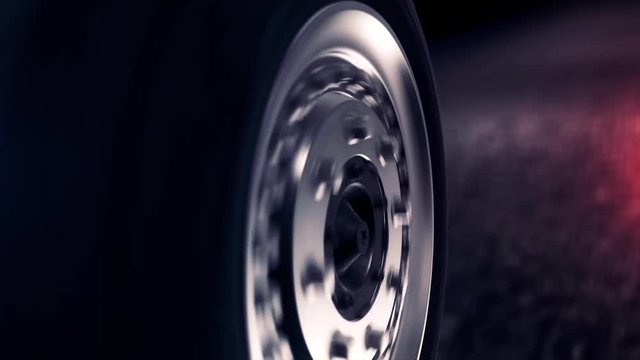 Side view of abstract car wheel driving back on black road. Close up for car wheel with silver disc moving back on abstract black asphalt road.