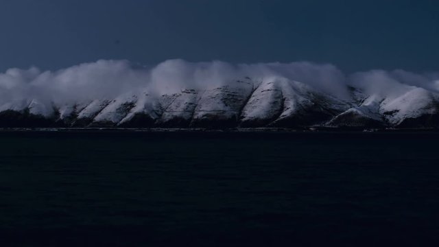 4K Time Lapse of Winter Lake and snow covered mountains with mystery fog clouds at night footage for different projects. Shooted in Armenia lake (Sevan).