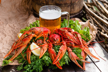 boiled crayfish with lemon, herbs and beer on a wooden table