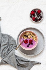 Obraz na płótnie Canvas Bowl of oat granola with yogurt, fresh raspberries, cranberries