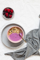 Bowl of oat granola with yogurt, fresh raspberries, cranberries