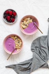 Bowl of oat granola with yogurt, fresh raspberries, cranberries